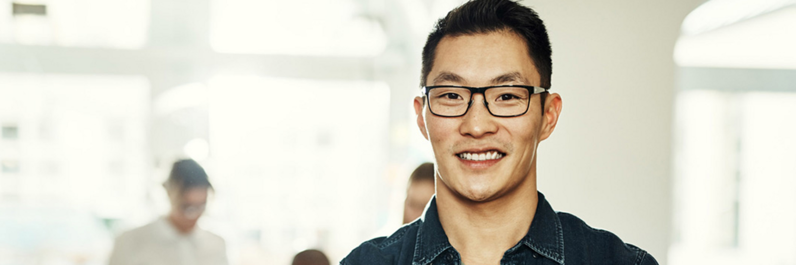 Asiatisch aussehender Mann mit Brille lächelt